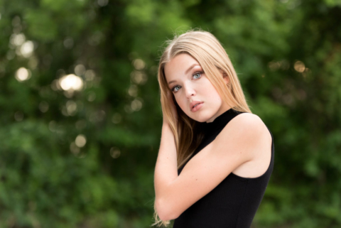 seneca valley high school senior poses in front of greenery during her senior pictures in cranberry twp pa