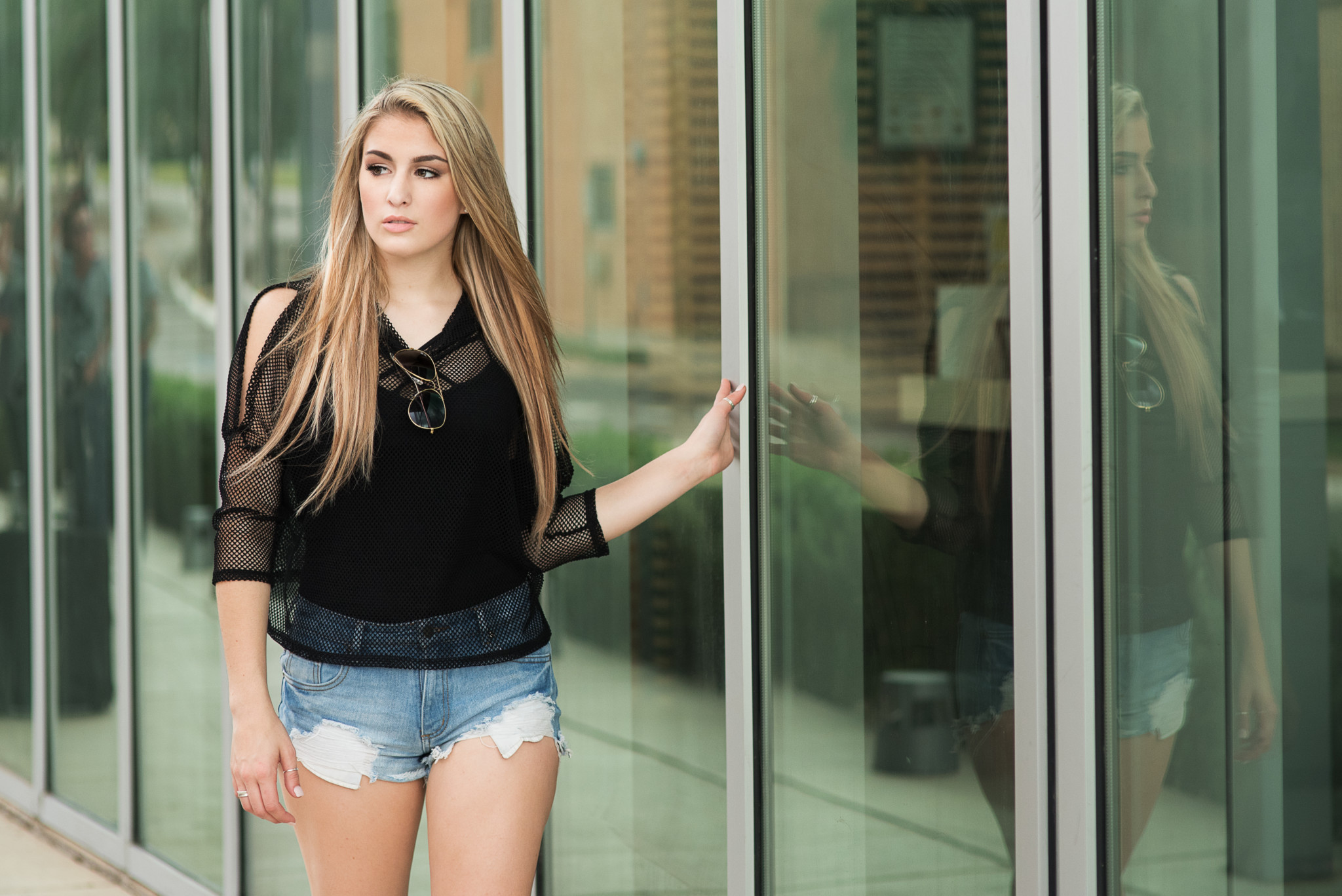mars high school senior walks along glass wall during her urban senior pictures in cranberry twp pa