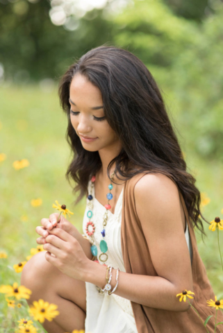 north allegheny high school senior kneels in field of yellow flowers during her senior pictures in wexford pa